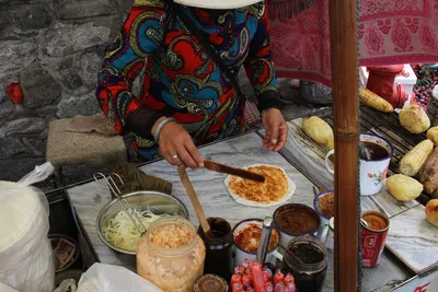 A Dali street vendor spreading sauce on a grilled erkuai rice sheet