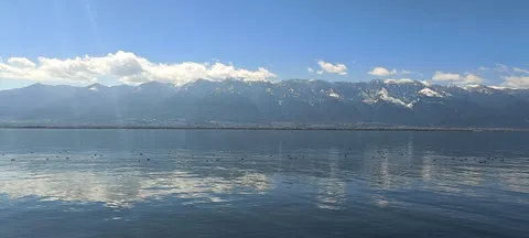 Erhai Lake reflecting snow-streaked Cangshan under a blue sky