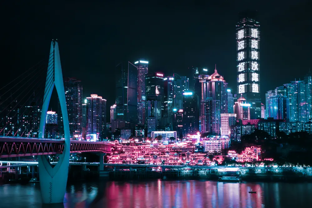 Hongya Cave's stacked riverside buildings glowing gold at night in Chongqing
