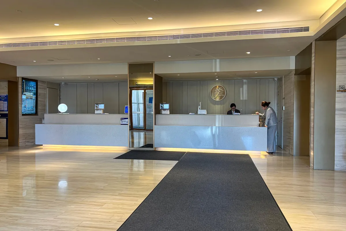 A hotel reception desk in China with staff checking in a guest