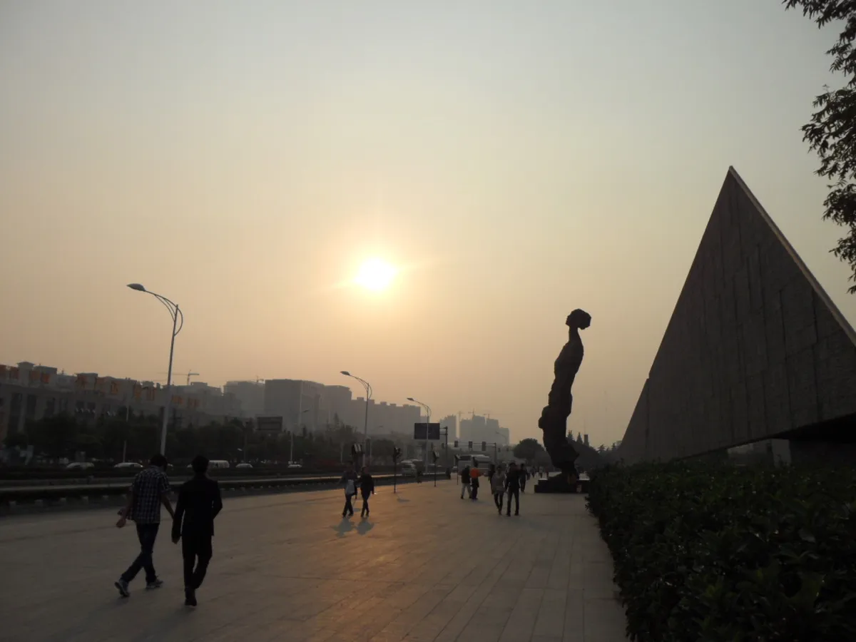 The angular stone memorial wall and sculpture at the Nanjing Massacre Memorial Hall at dusk
