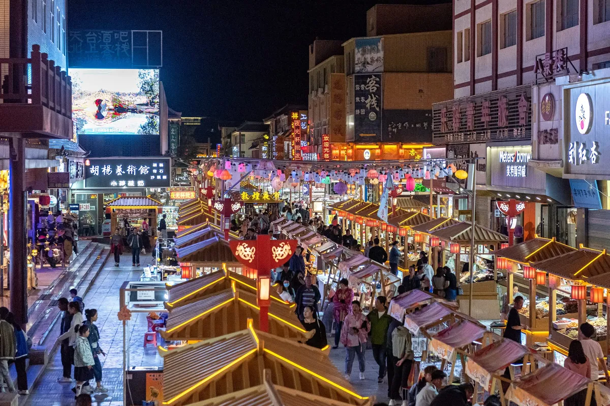 Lantern-lit stalls lining a pedestrian street at Dunhuang Night Market