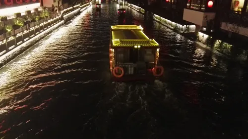 An illuminated traditional cruise boat gliding down the lantern-lit Qinhuai River at night