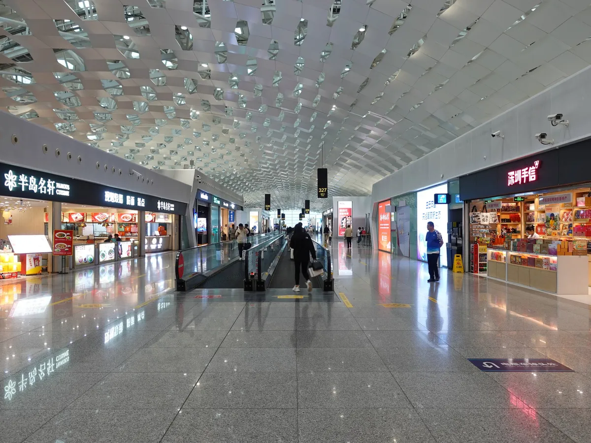 The honeycomb-patterned ceiling and shopping concourse inside Shenzhen Bao'an International Airport Terminal 3