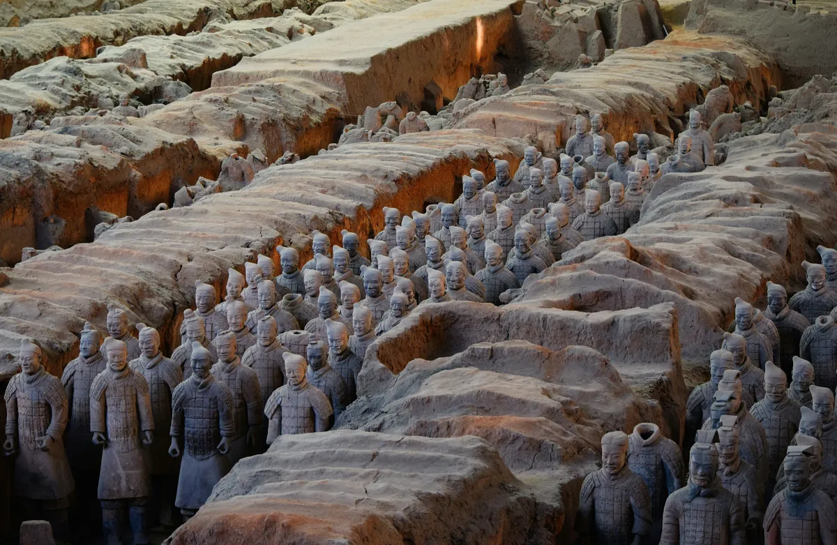 Rows of individually detailed Terracotta Army soldiers in an excavation pit