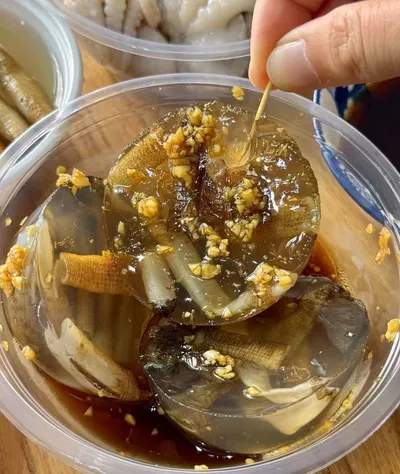 A dish of tusun jelly — sea worm jelly — topped with minced garlic and a soy dipping sauce