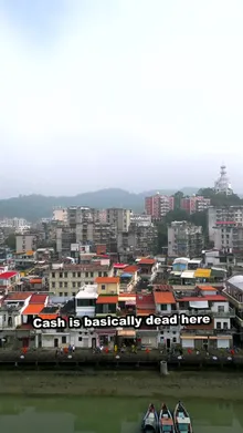Opening frame of our 30-second video: a Chinese riverside town with the caption 'Cash is basically dead here'